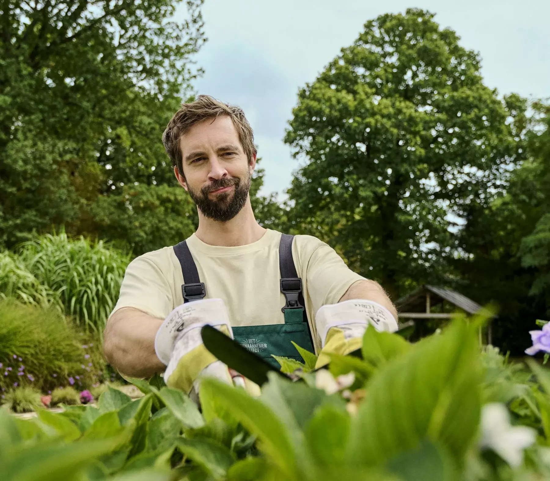 Professionele tuinaannemer snoeit struiken in nieuwe tuinontwerp