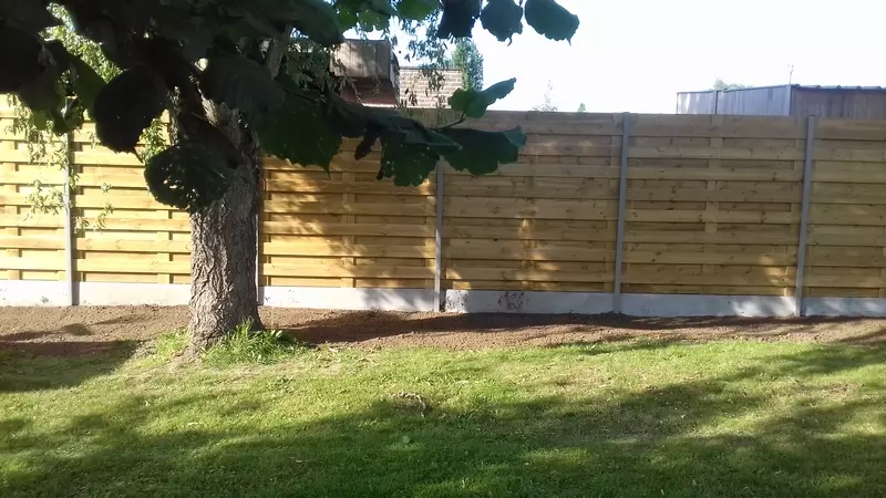 Houtenafsluiting met grijze alu palen 