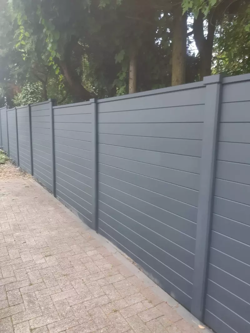 Betonomheining Luxline gecoat in RAL kleur, afgewerkt met afdeklatten en petten.