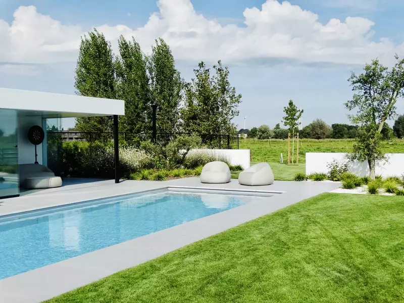 Biopool met lichtgrijze liner en afgewerkt met mega tegel smooth, poolhouse, tuinaanleg en accessoires