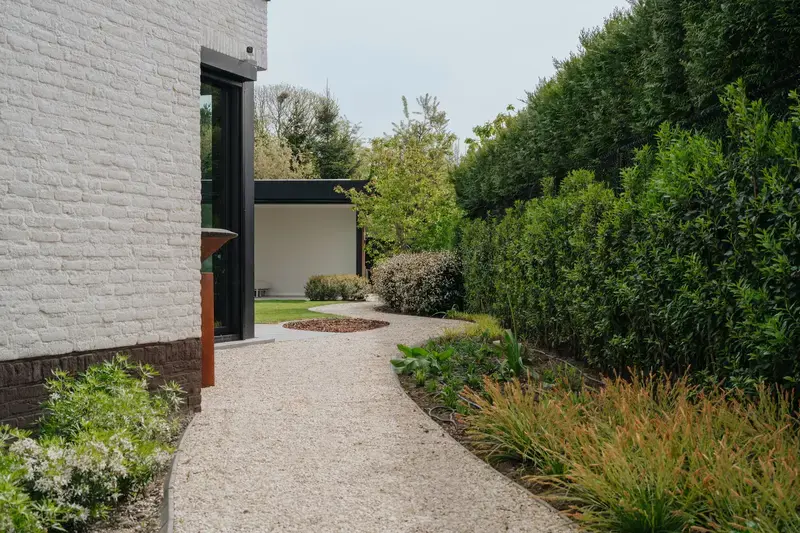 Glooiend pad langs plantenborders langs het huis
