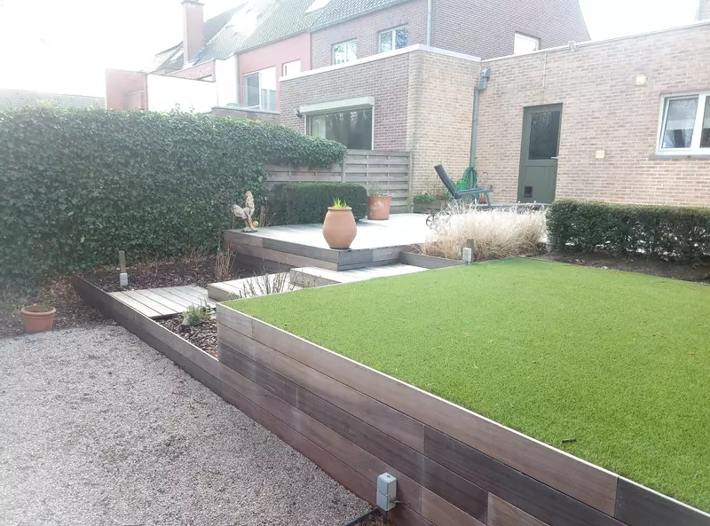 Heraanleg achtertuin in padouk hardhouten terrasplanken afgewerkt met kunstgras