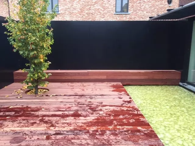 Aanlig Patio met siervijver en hardhouten terras in padouk met zitbank en plantenborder.