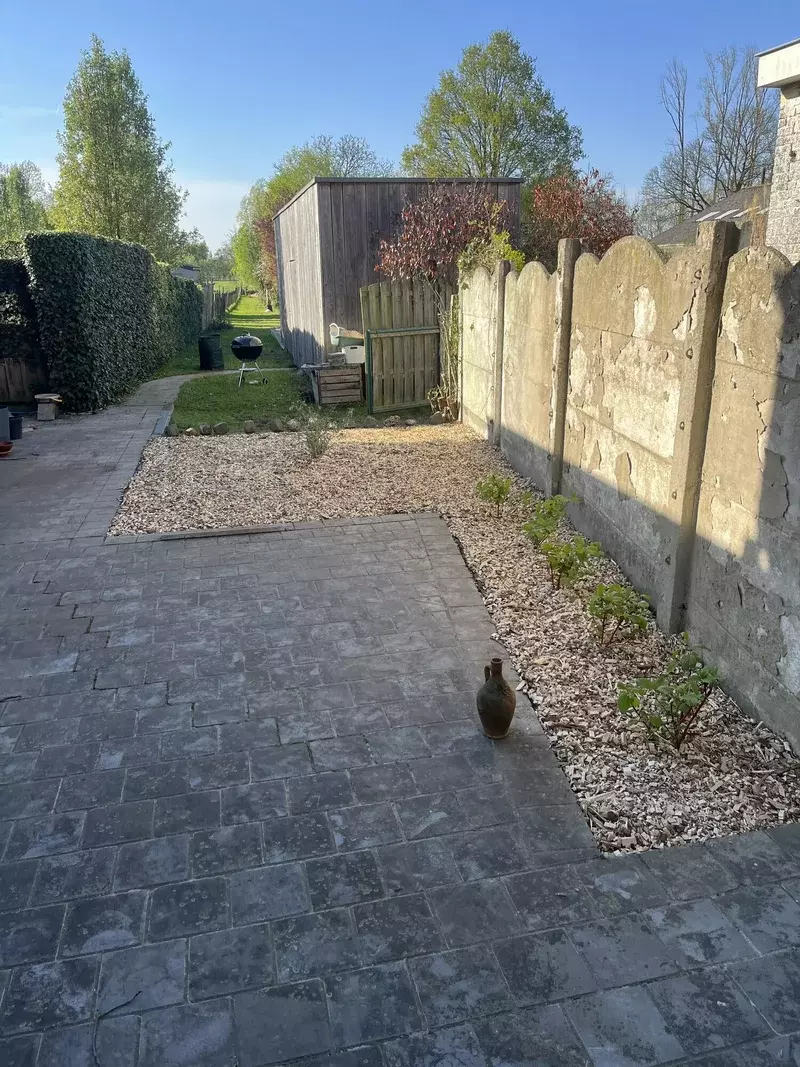Eerst bomen, struiken en onkruid weggehaald, daarna propere schors gelegd en opnieuw beplant (Planten: Cornus Alba en Buddleja Davidii)