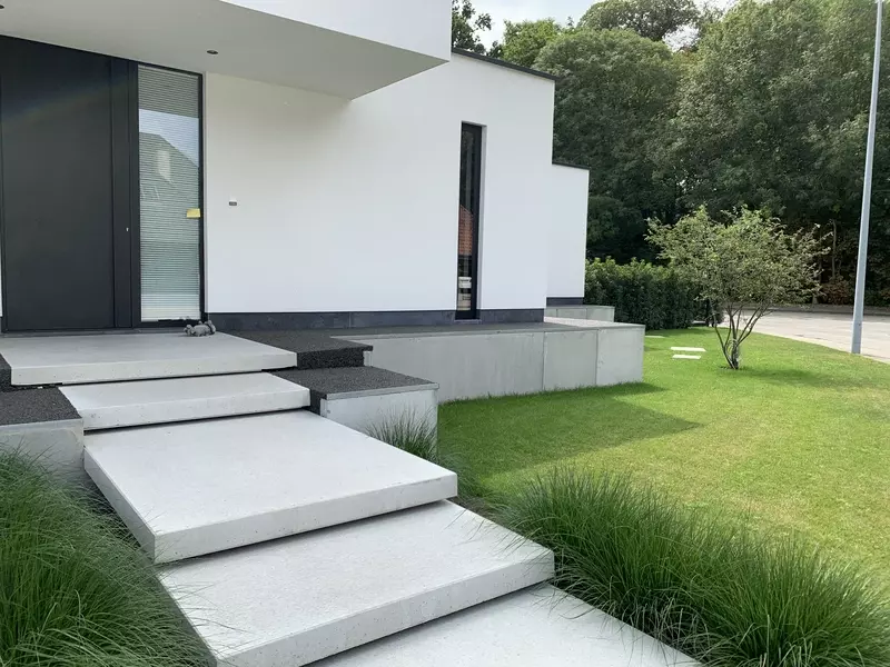Totaalproject van ontwerp tot realisatie, oprit en tuinpaden in waterdoorlatende verharding, niveauverschil werd opgevangen door het plaatsen van keerwanden en betonnen vloerplaten als treden naar de voordeur