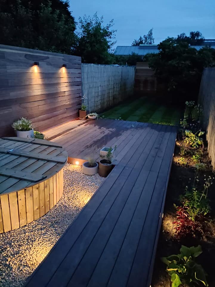 Tuinrenovatie met een padouk terras, grasmatten, hottube, beregening en In-lite verlichting.