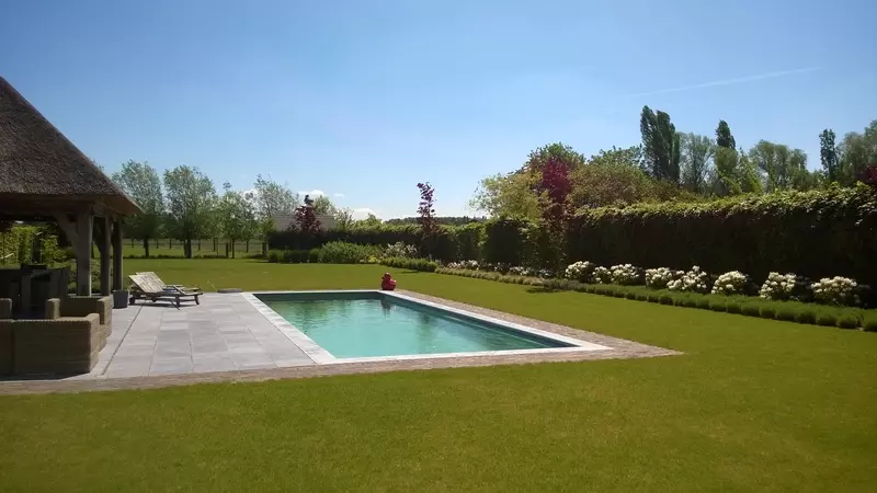 Totaal project uit ontwerp: grondwerken, zwembad, poolhouse, gazon, terrassen, aanplantingen