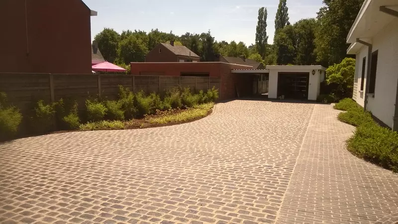 Totaal project tuinrenovatie uit ontwerp: grondwerken, gazon, oprit, waterafvoeren, terras, aanplantingen en verlichting