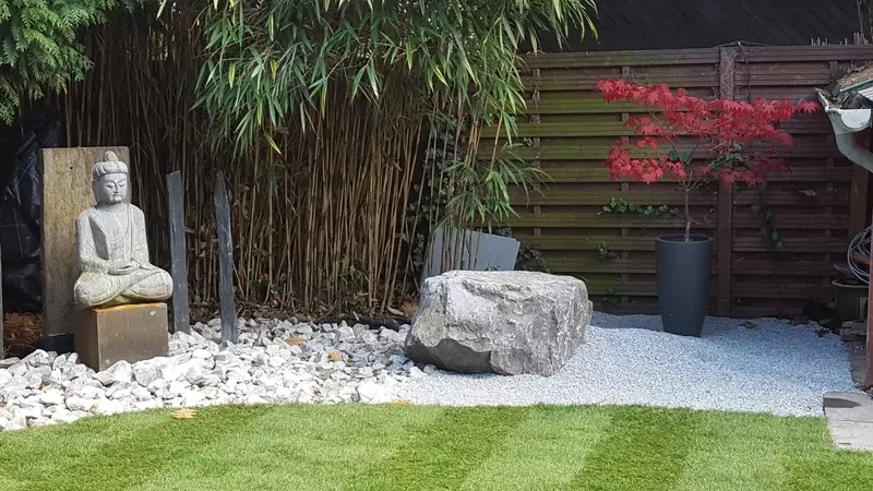 Totaal project tuinrenovatie uit ontwerp: grondwerken, gazon, terras, steenkorven, aanplantingen en verlichting met Boeddha