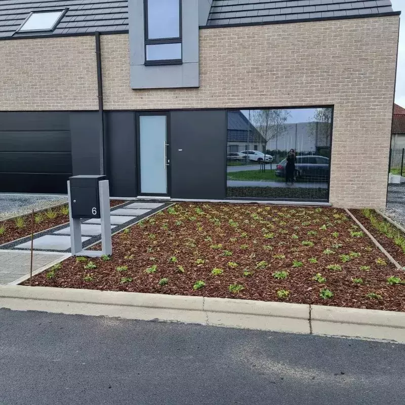 Aanleg wandelpad met stapstenen en grind stabilisatiematten. Baplanting en schors voorzien.