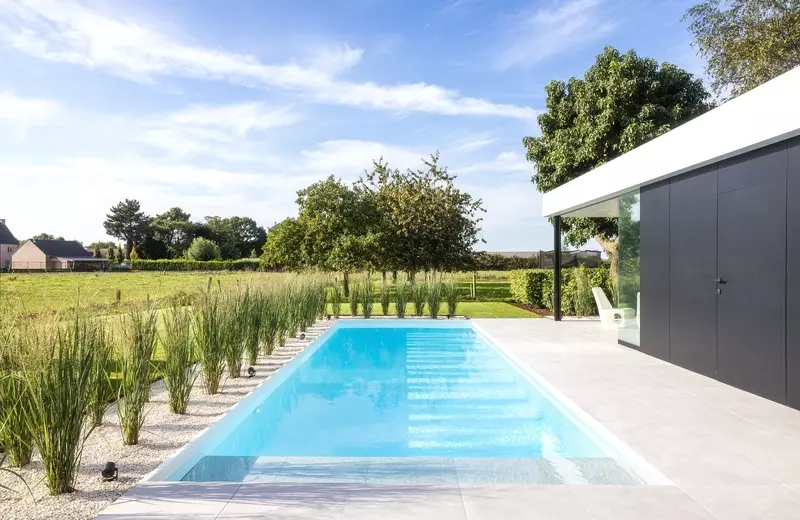 Biopool met witte liner, randafwerking met wit aluminium profiel en keramische tegel, grind en siergrassen
