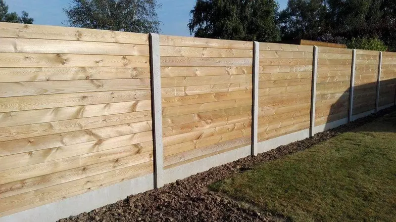plaatsing houten afsluiting tussen betonpalen