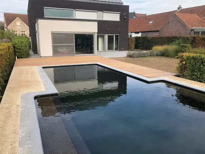 totaalproject; BIO-zwemvijver, afgewerkt met graniet boord, houten terras in Ipé en terras in keramische tegels van 122 x 122cm te Ternat