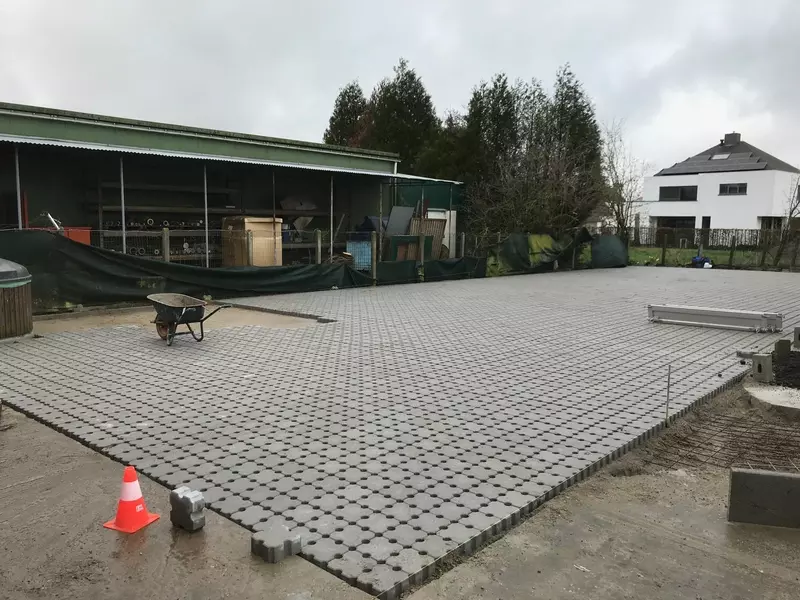 Aanleg bedrijfskoer met waterpasserende betondallen