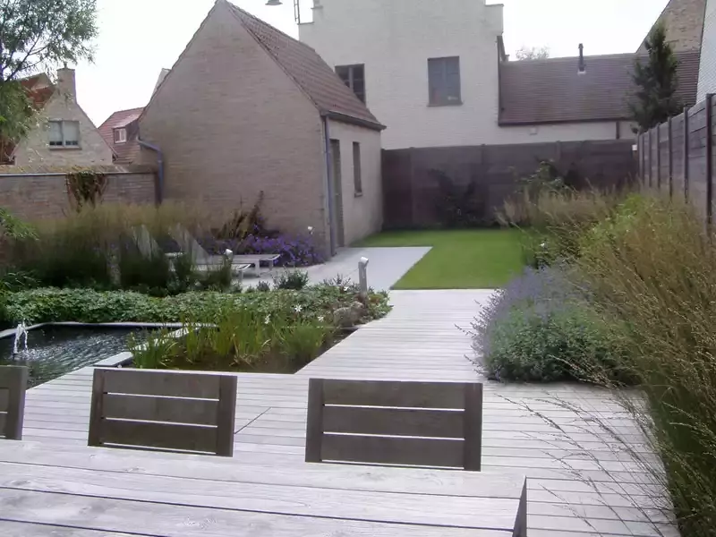 Gezellige stadstuin met vijver, een ruim eetterras en een zonneterrasje met 2 ligzetels. 