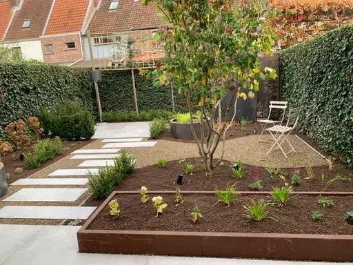 Gezellige stadstuin met leuk zonneterras, stapstenen en cortenstaal elementen. Van Ontwerp tot realisatie.