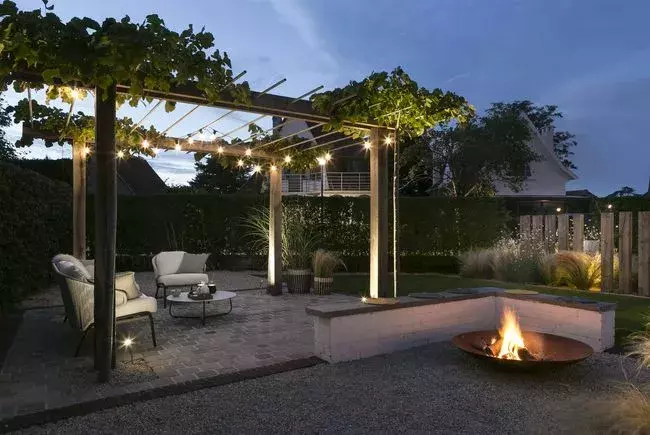 Het bestaande tuinmuurtje moest behouden blijven en werd omgetoverd tot een zithoekje om gezellig te keuvelen rond de vuurschaal.